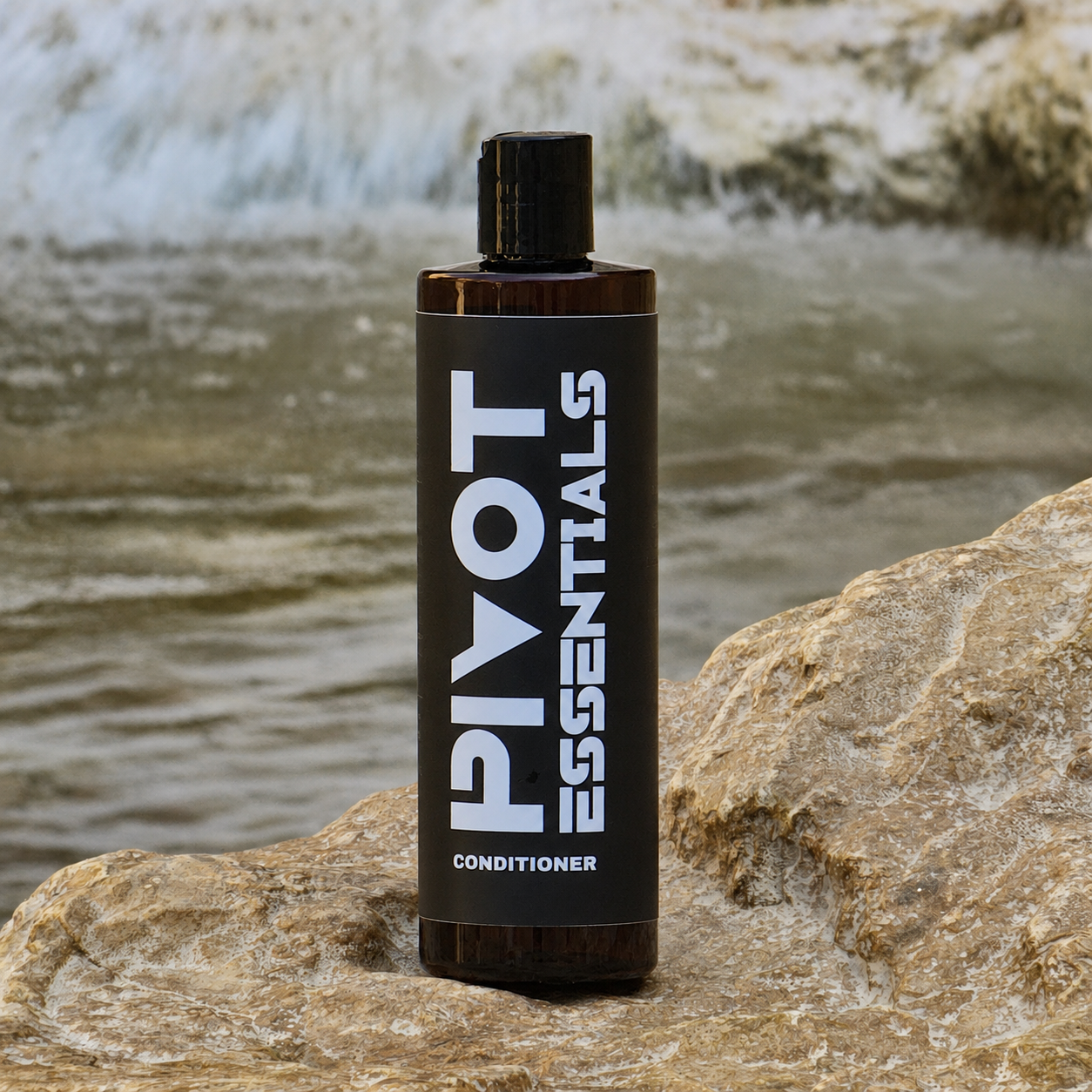 Pivot Essentials conditioner standing on a textured stone surface